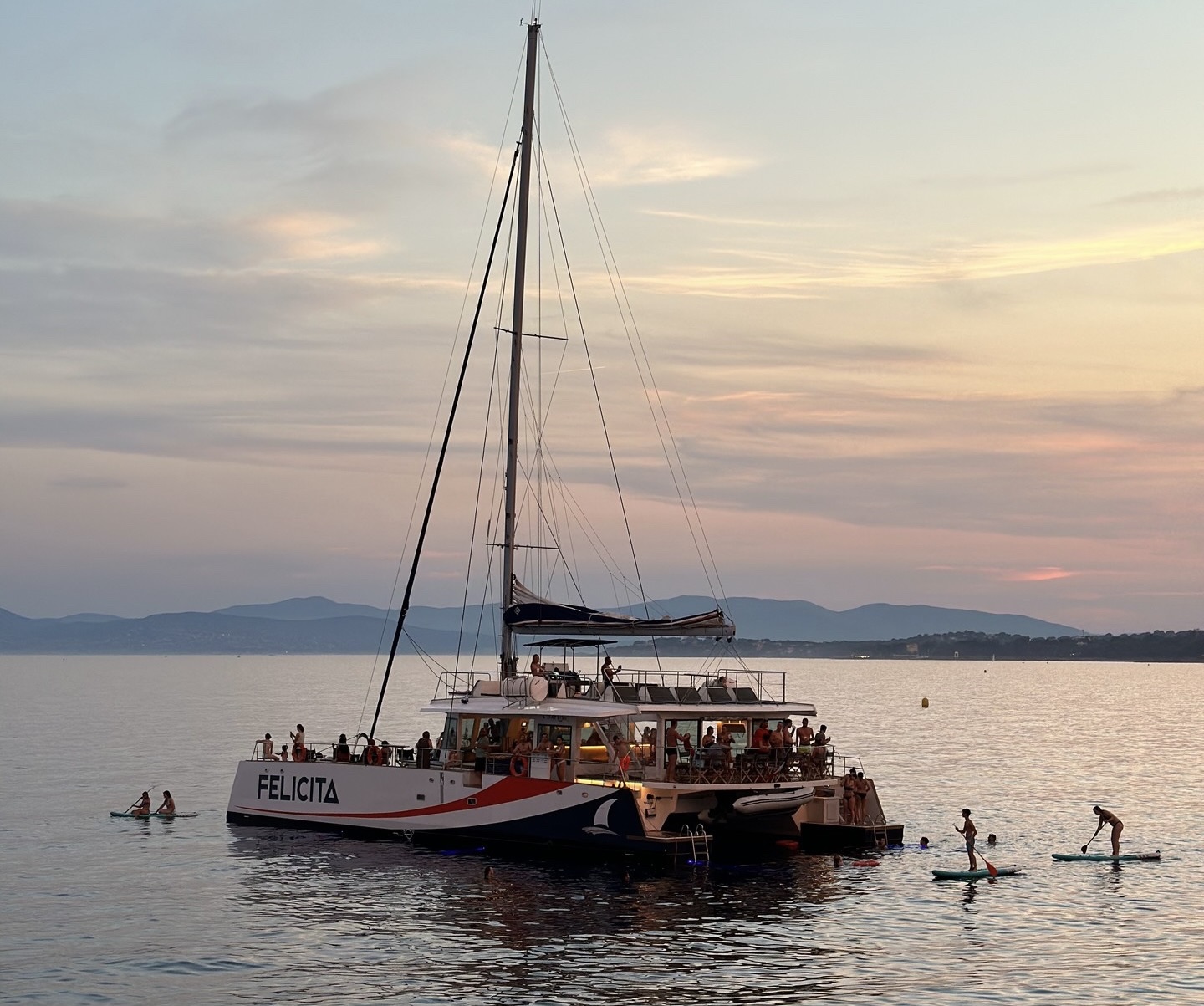 Le maxi-catamaran Félicita d’AMC Cape Grace en Méditerranée au coucher du soleil, accueillant un séminaire d’entreprise mêlant détente et activités écoresponsables