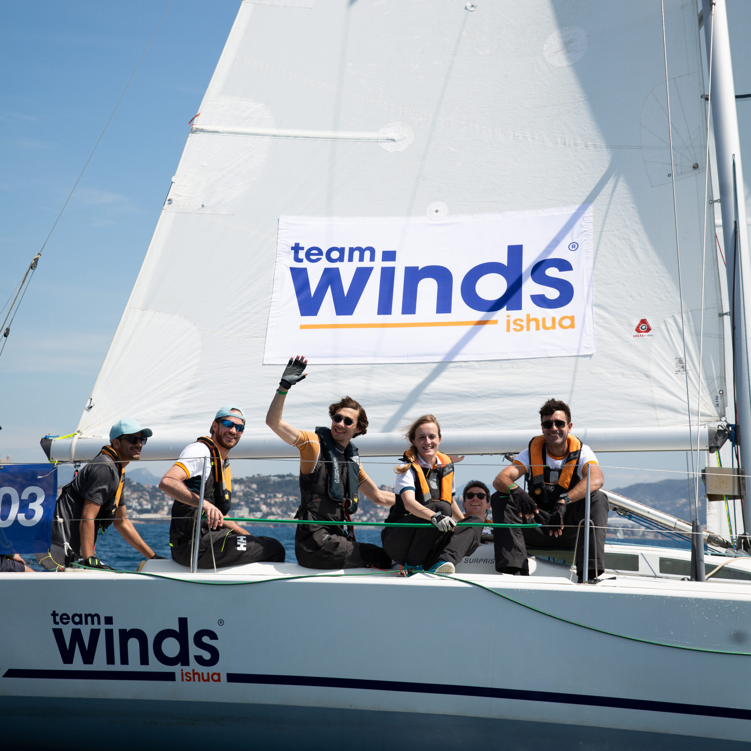 Un équipage souriant participant à une régate en voilier avec Team Winds, illustrant une activité de team-building en mer dans le cadre d’un séminaire d’entreprise